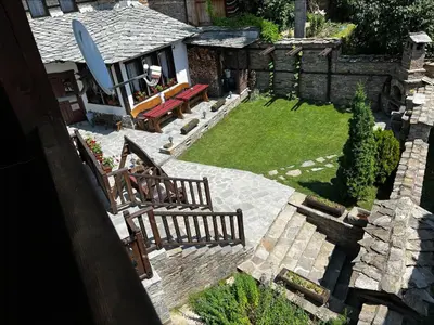 an aerial view of a backyard with two wooden benches at Кондеви къщи in Kovachevitsa