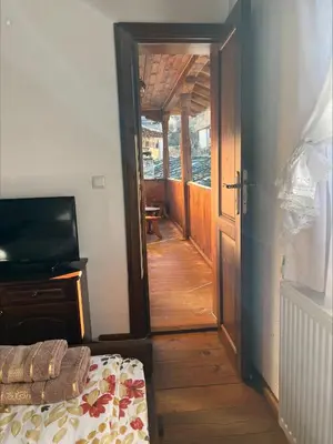 an open door to a room with a wooden floor at Кондеви къщи in Kovachevitsa