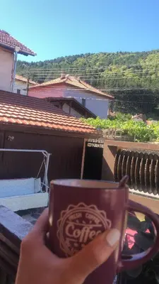 a person holding up a cup of coke at Guesthouse Gaby in Sapareva Banya
