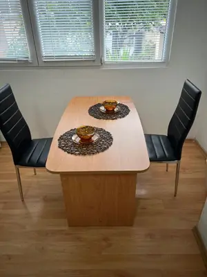 a wooden table with two chairs and two cups on it at Мини Студио Рози in Sandanski