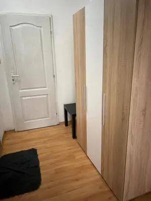 a room with a door and a table and a wooden floor at Мини Студио Рози in Sandanski