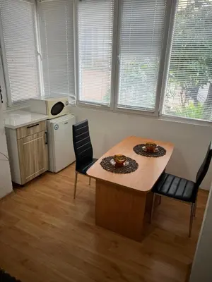 a kitchen with a table and chairs in a room at Мини Студио Рози in Sandanski