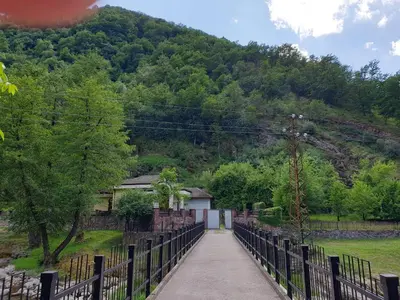 a walkway with a fence and a mountain in the background at Guest House Fedor in Ribarica