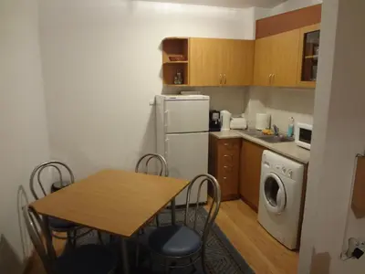 a small kitchen with a table and a white refrigerator at Deluxe Apartments in Pamporovo
