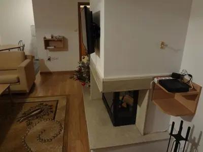 a living room with a fireplace and a television at Deluxe Apartments in Pamporovo