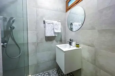 a bathroom with a shower and a sink and a mirror at Deluxe Central Rooms in Karlovo