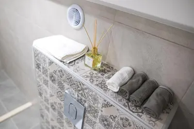 a shelf in a bathroom with towels on it at Deluxe Central Rooms in Karlovo