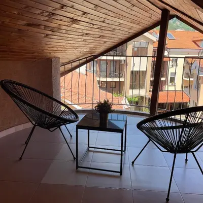 two chairs and a table on a balcony with a view at Deluxe Central Rooms in Karlovo