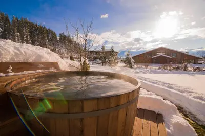 a wooden hot tub in a snow covered yard at Villa Chalet Everest in Bansko