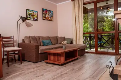 a living room with a couch and a table at Stand'Art - апартамент , Смолянски езера in Smolyan