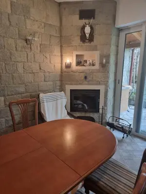 a dining room with a table and a fireplace at villa Tia Maria in Hisarya