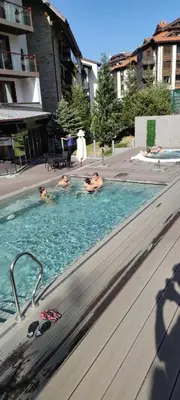 three people are swimming in a swimming pool at St Ivan Rilski Spa Luxury apartment Bansko & Free SPA in Bansko
