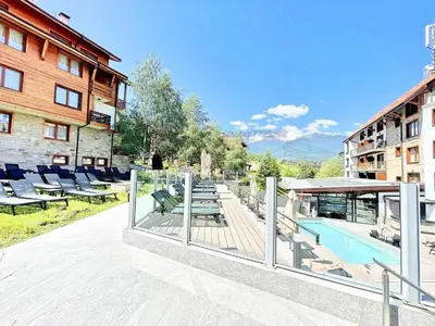 a resort with a pool and chairs and a building at St Ivan Rilski Spa Luxury apartment Bansko & Free SPA in Bansko