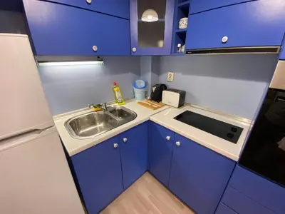 a small kitchen with blue cabinets and a sink at Modern & Central 1BR Apartment with lovely terrace in Plovdiv