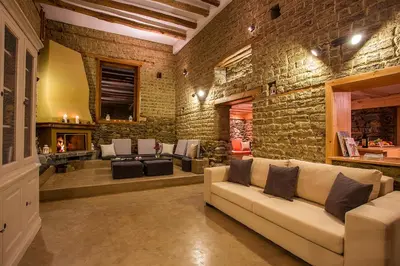 a living room with a couch and a brick wall at Garmen Hills Guest Houses in Garmen