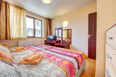 a bedroom with a large bed and a window at Castle Romance - Pamporovo in Pamporovo