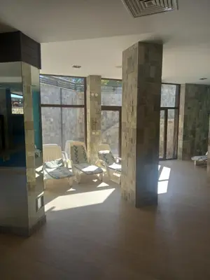 a large room with chairs and windows in a building at Bansko All Seasons - Cozy Apartments Near Gondola & Mountain Views in Bansko