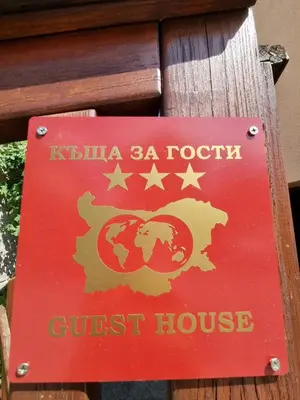 a sign for a guest house on a post at Kaloyanova House Bansko in Bansko