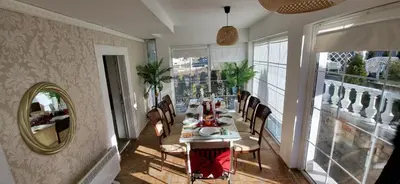 a dining room with a table and a mirror at Белият кът in Sapareva Banya