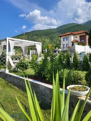 a garden with plants and a house in the background at Белият кът in Sapareva Banya