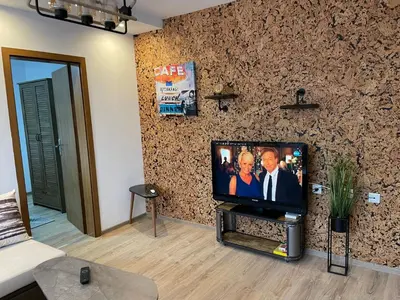 a living room with a flat screen tv on a wall at Апартамент Стил in Chepelare