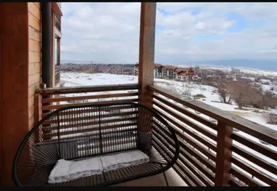 a bench on a balcony with a view of the snow at Luxury Suite Ivana in Bansko