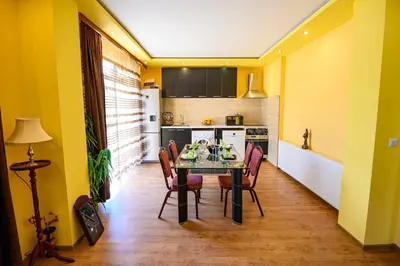 a dining room with a table and chairs in a kitchen at Guest House Dinaya in Dobrinishte