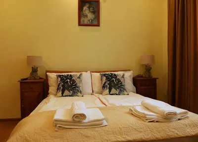 a bedroom with a bed with towels on it at Guest House Dinaya in Dobrinishte