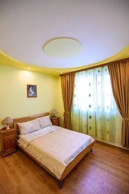 a bedroom with a bed and a large window at Guest House Dinaya in Dobrinishte