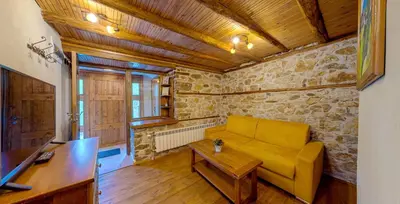 a living room with a yellow couch and a table at Къща за гости 