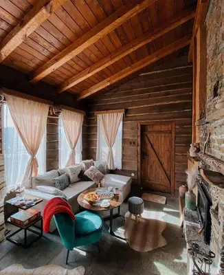 a living room with a couch and a table at Панорама хаус Лещен и еко къщи Дървена и Землянка in Leshten