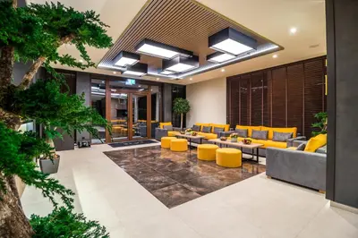 an office lobby with yellow chairs and tables at EMAR HOTEL & SPA in Sapareva Banya