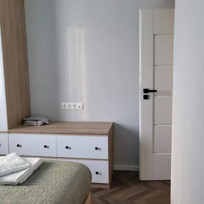 a bedroom with a bed and a wooden dresser at New luxury apartment next to subway with garage in Sofia