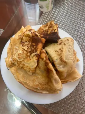 a plate of food with pancakes on a table at Хижа Ловна в Рила in Panichishte