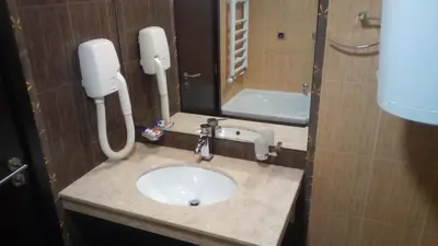 a bathroom with a sink with a phone and a mirror at Alexander 3327 in Bansko