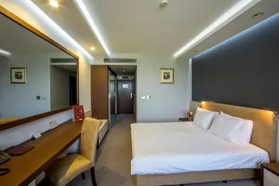 a bedroom with a bed and a desk and a mirror at Uva Nestum Wine & SPA in Gotse Delchev