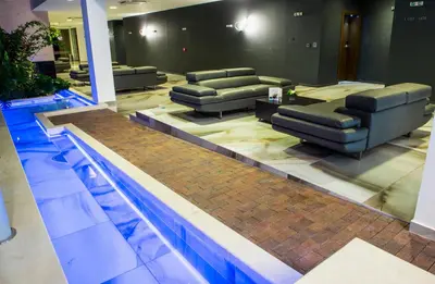 a waiting room with couches and a swimming pool at Uva Nestum Wine & SPA in Gotse Delchev