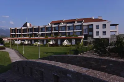 a building with a stone wall in front of it at Uva Nestum Wine & SPA in Gotse Delchev