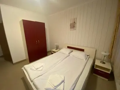 a bedroom with a white bed with two white pillows at Червената Шапчица Апартамент Гранд Манастира in Pamporovo