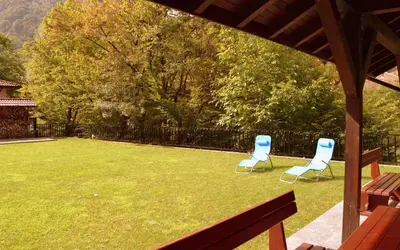two chairs sitting on a lawn with a fence at Boyana Vacation Houses in Cherni Vit