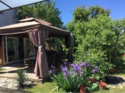 an umbrella in a garden with purple flowers at Къща ИВОНА in Sapareva Banya
