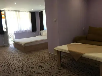 a hotel room with two beds and a couch at Къща ИВОНА in Sapareva Banya