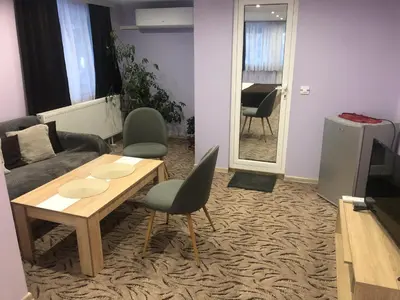 a living room with a couch and a table and chairs at Къща ИВОНА in Sapareva Banya