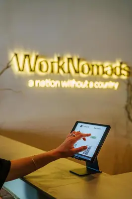 a woman is pointing at a laptop computer at WorkNomads LAB Hotel in Sofia