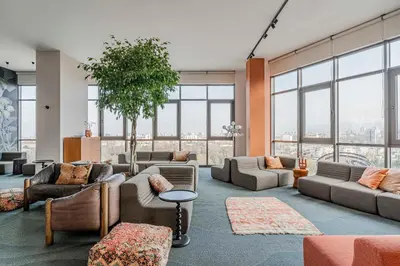 a living room with couches and tables and windows at WorkNomads LAB Hotel in Sofia