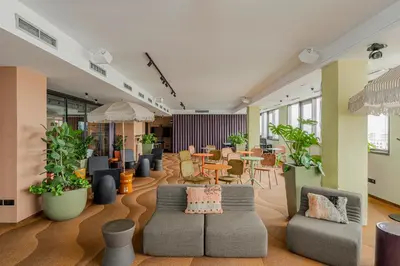 a living room with couches and tables and plants at WorkNomads LAB Hotel in Sofia