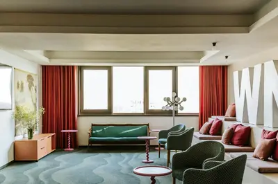 a living room with a green couch and chairs at WorkNomads LAB Hotel in Sofia