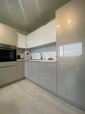 a kitchen with white cabinets and a microwave at Brand new and modern apartment directly next to the metro station in Sofia