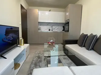 a living room with a couch and a glass coffee table at Brand new and modern apartment directly next to the metro station in Sofia