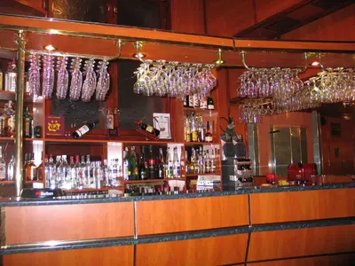 a bar with many wine glasses hanging above it at Darling Hotel in Sofia